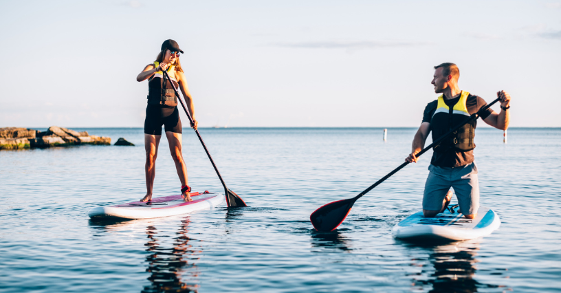 Lidé pádlují na paddleboardech u klidného moře