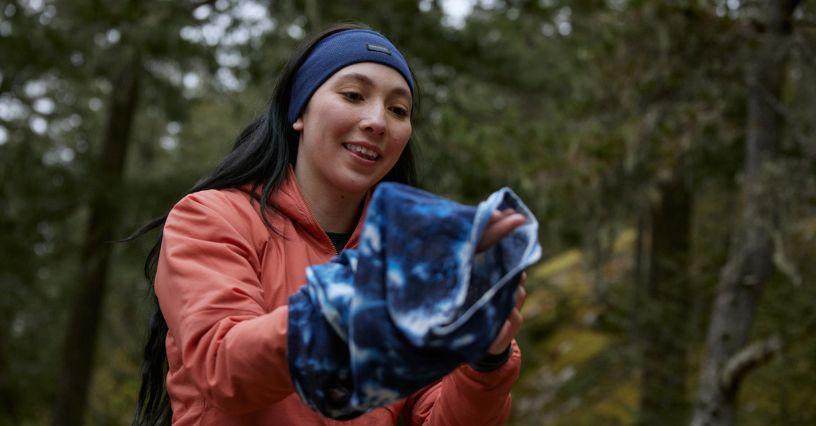 Žena drží sportovní oblečení v přírodě